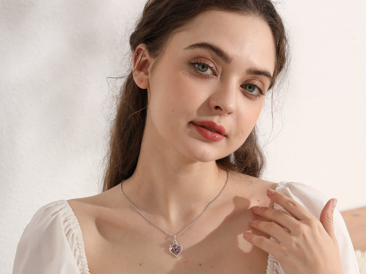 Beautlace catalog photograph of the Rose Heart necklace worn with a navy cardigan